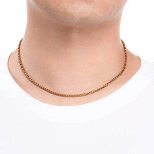 Collier minimaliste en acier inoxydable doré porté par un mannequin sur fond blanc