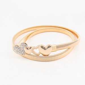 Elastic gold metal spring belt for women featuring a sparkling rhinestone heart buckle