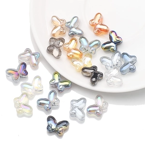 Mix of colorful butterfly-shaped glass beads for DIY jewelry on a white plate