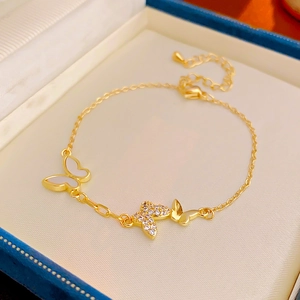 Detail of gold bracelet featuring butterfly pendants with mother of pearl and cubic zirconia