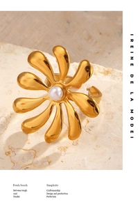 Macro shot of gold-plated flower ring with pearl inlay on a stone background