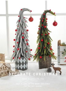 Close-up of artificial mini snow-flocked and green Christmas trees with red berry decor