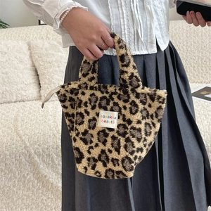 Détail d'un sac à main en peluche léopard avec fourrure douce et étiquette en tissu sobre