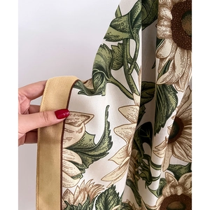 Detail of sunflower print scarf showing herringbone texture and contrast hem stitching