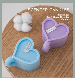 Detail of heart-shaped scented candles in lavender and light blue on a wooden tray
