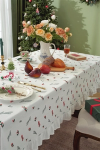 Detail of white cotton tablecloth with festive red berries and ruffled edge design