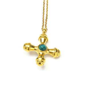 Detailed macro view of 18k gold-plated titanium cross pendant with green gemstone inlay