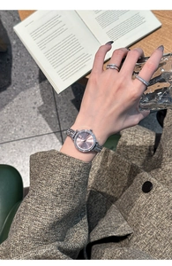 Elegant silver watch with pink dial and rhinestone bezel worn in a lifestyle setting