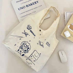 Detail of canvas tote bag with astronaut cow print, magnetic button and accessories