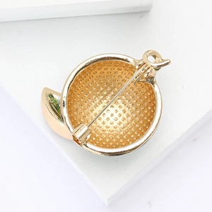Detail of round watermelon brooch showing the gold mesh base and sturdy safety pin closure