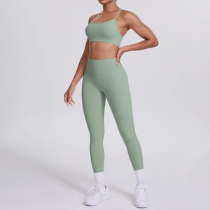 Detail eines salbeigrünen Yoga-Sets aus Nylon mit gekreuztem Rücken-BH und hoher Leggings