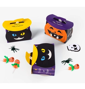 Close-up of Halloween candy gift boxes featuring pumpkin and black cat designs with handles