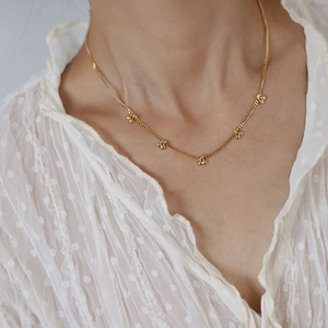 Detail showing the length and drape of the dainty gold cherry pendant necklace on neck