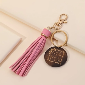 Close-up of pink leather tassel and wooden charm with gold MAMA engraving on keyring