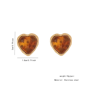 Macro view of amber heart earrings with gold trim and stainless steel posts