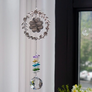 Rainbow crystal suncatcher with floral wreath and grateful heart pendant hanging by window