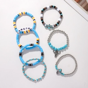 Detail of 6-piece bohemian bracelet set featuring turquoise beads and cow skull charms
