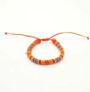 Close-up of colorful Bohemian hand-woven surf bracelet with adjustable orange drawstring