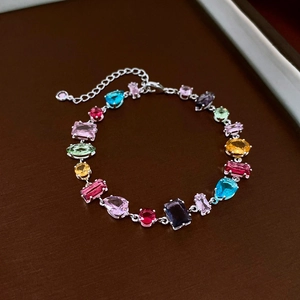 Detailaufnahme eines silbernen Armbands mit bunten Tropfen- und quadratischen Edelsteinen
