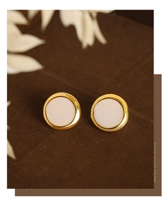 Detail shot of elegant geometric round earrings with cream inlay on a velvet background