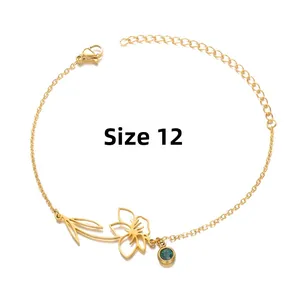 Detail of gold flower bracelet with green birthstone pendant and adjustable chain