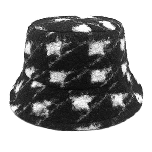 Close-up of thick plush teddy fleece bucket hat featuring black and white houndstooth pattern
