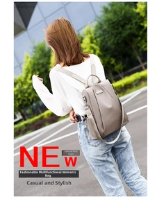 Outdoor shot of water-resistant grey nylon backpack worn by a model in casual wear