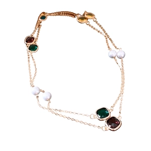 Double-layered gold chain necklace with colorful gemstones and white glass pearls