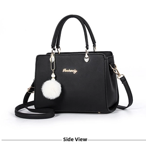 Detail of black PU leather crossbody bag with Danbaoly logo and white plush ball charm