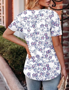 Outdoor back view of a white floral t-shirt featuring purple and blue flower patterns