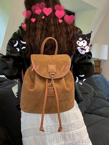 Rear view of model wearing a vintage brown suede backpack with drawstring closure