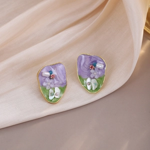 Detailed macro view of French vintage square pearl earrings with green and purple enamel