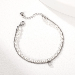 Elegant double-layer bracelet with white pearls and silver textured chain on white background