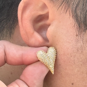Elegant gold heart stud earrings with cubic zirconia pavé shown on model's ear
