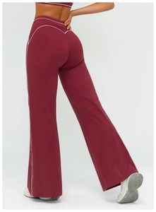 Detail view of burgundy flare yoga pants featuring white contrast stitching and high waist