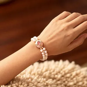 Double-row pearl bracelet with a pink gemstone center in gold-plated vintage style