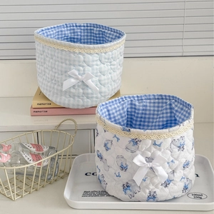 Quilted lace storage baskets with blue bows and floral patterns for desktop organization