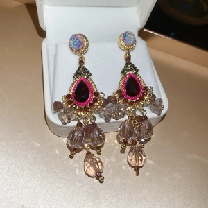 Macro shot of chandelier earrings with red teardrop gemstones and crystal tassels