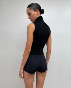 Detail view of the back profile of slim-fit black low-waist hot pants and a sleeveless top
