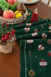 Detail of green Christmas table runner with jacquard Santa Claus and gift patterns