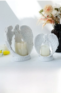 Detail shot of white prayer angel candle holder set showing intricate wing feather textures