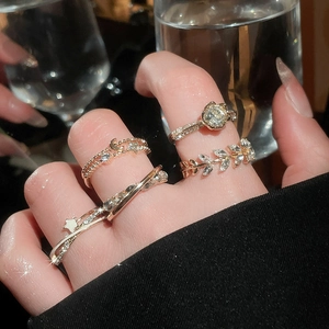 Detail shot of gold zircon ring set with star and moon charms worn on fingers