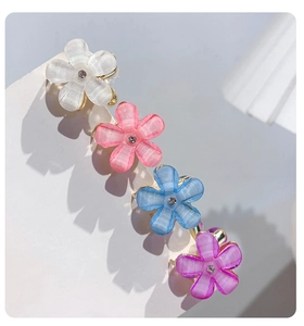 Detailed view of floral hair clips with translucent opal texture and crystal centers