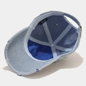 Vue intérieure d'une casquette en denim délavé bleu clair avec bord usé et sangle réglable
