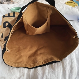 Internal structure of large canvas tote bag showing inner pocket and khaki fabric