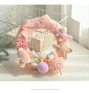 Close-up of a pink plush Christmas wreath with cute sheep, LED lights, and bow decoration