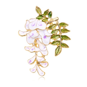 Macro detail of gold-plated flower brooch with white petals and purple accents