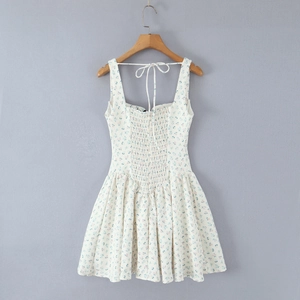 Détail de robe à fleurs avec dos lacé et taille froncée sur un cintre en bois