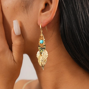 Vue détaillée des boucles d'oreilles en forme de feuille avec perles de turquoise