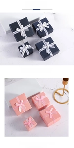 Detail of square and rectangular jewelry gift boxes with elegant ribbon bows on marble